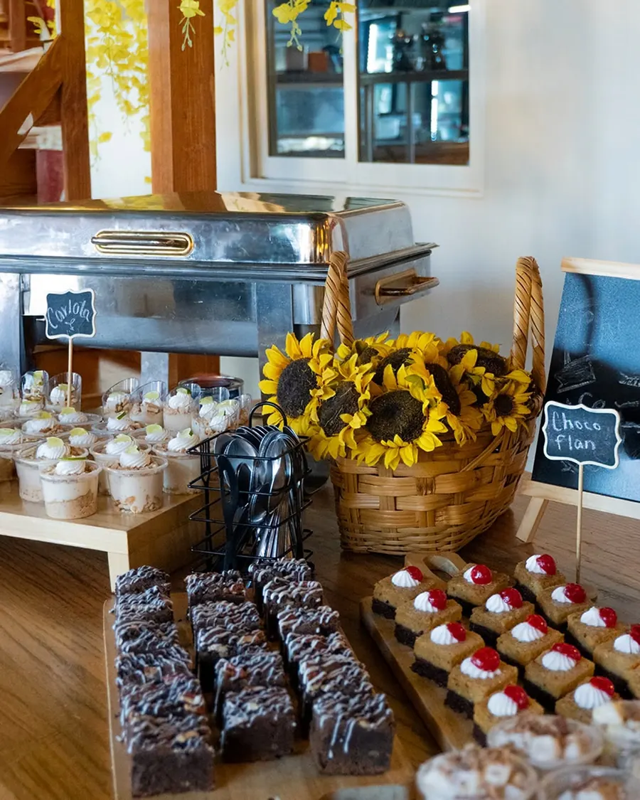 Mesa del buffet con postres, panes y girasoles
